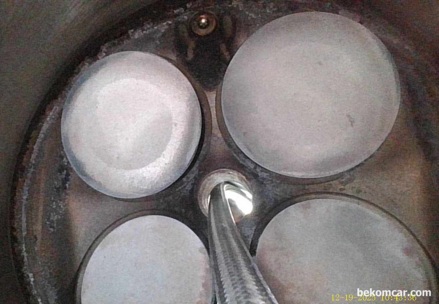 중고차 구입후 엔진내시경 점검사진, GM대우 알페온 2014년 V6 3.0L LFW GDI 엔진이다. 12시 방향에 있는것이 인젝터 분사 노즐이다. 6개 분사노즐 구멍이 있다. 1개 실린더에 흡기밸브 2개 & 배기밸브 2개 총 4개의 밸브가 있다. 특히 흡기쪽 밸브(왼쪽 큰 것) 카본상태는 상당히 좋은것 같다. 헤드쪽에 전체적인 카본상태는 나쁘지 않다.|بيكومكار  (bekomcar)