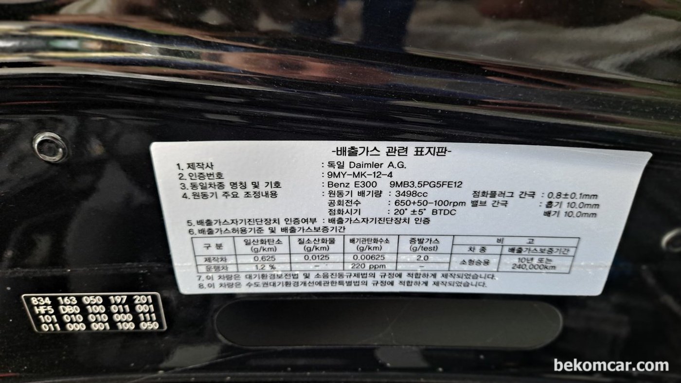 메르세데스 벤츠 W211 E300 배출가스 관련 스티커, 본네트에 있다. 점검시 점화플러그등 정보를 파악할수 있다.|베콤카 차량정밀진단
