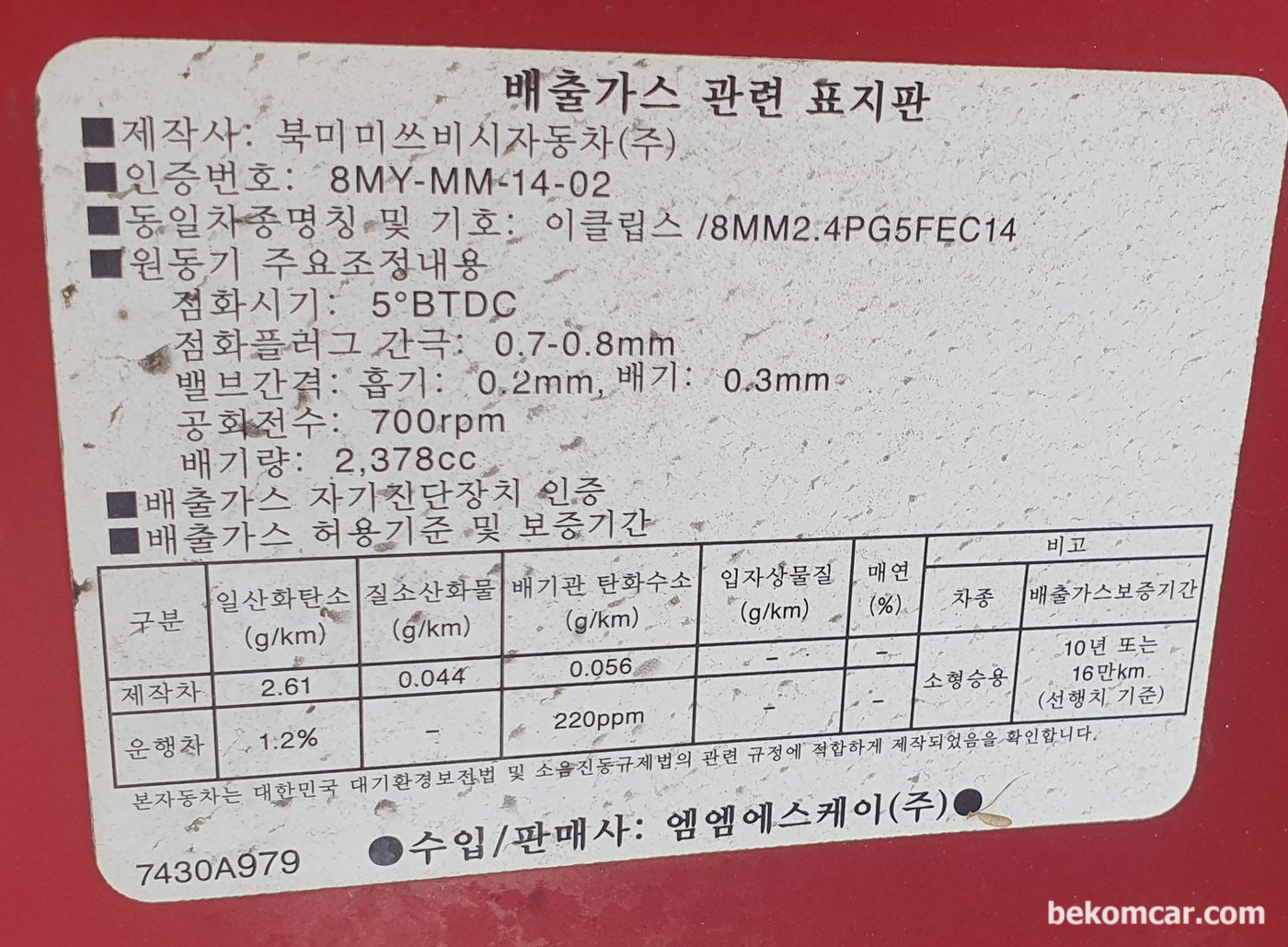 미쯔비시 이클립스 뱅크1 & 뱅크2 희박 농후 진단중 엔진룸 배기가스 스티커. 700RPM, 점화시점 5도 BTDC, 점화플러그 0.7-0.8mm 간극, 흡기밸브 0.2mm 배기밸브 0.3mm 정보이다.|بيكومكار  (bekomcar)