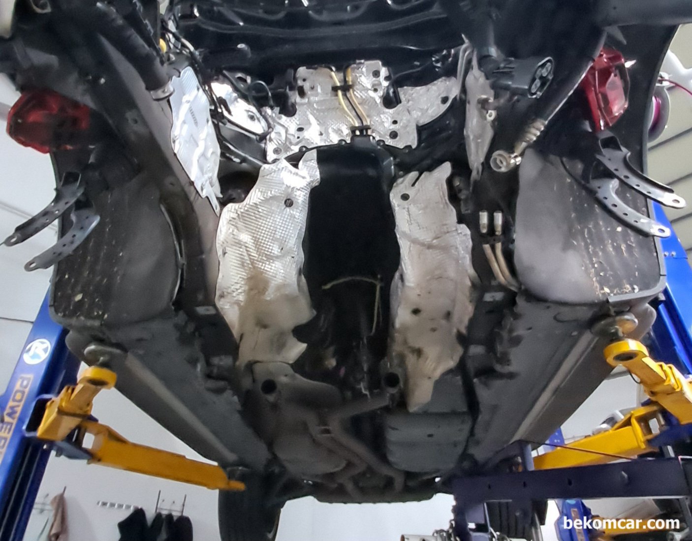 포르쉐 카이엔 엔진룸 뱅크2, 엔진 미션 토크컨버터 위치등 참고자료, 포르쉐 카이엔 리프트에 올려진 상태에서 엔진을 통채로 내린 상태이다. 가운데다 텅 비어있다. 엔진블럭 피스톤등 고장이 있는 경우에는 엔진을 내려서 작업한다.|ベコムカー (bekomcar)