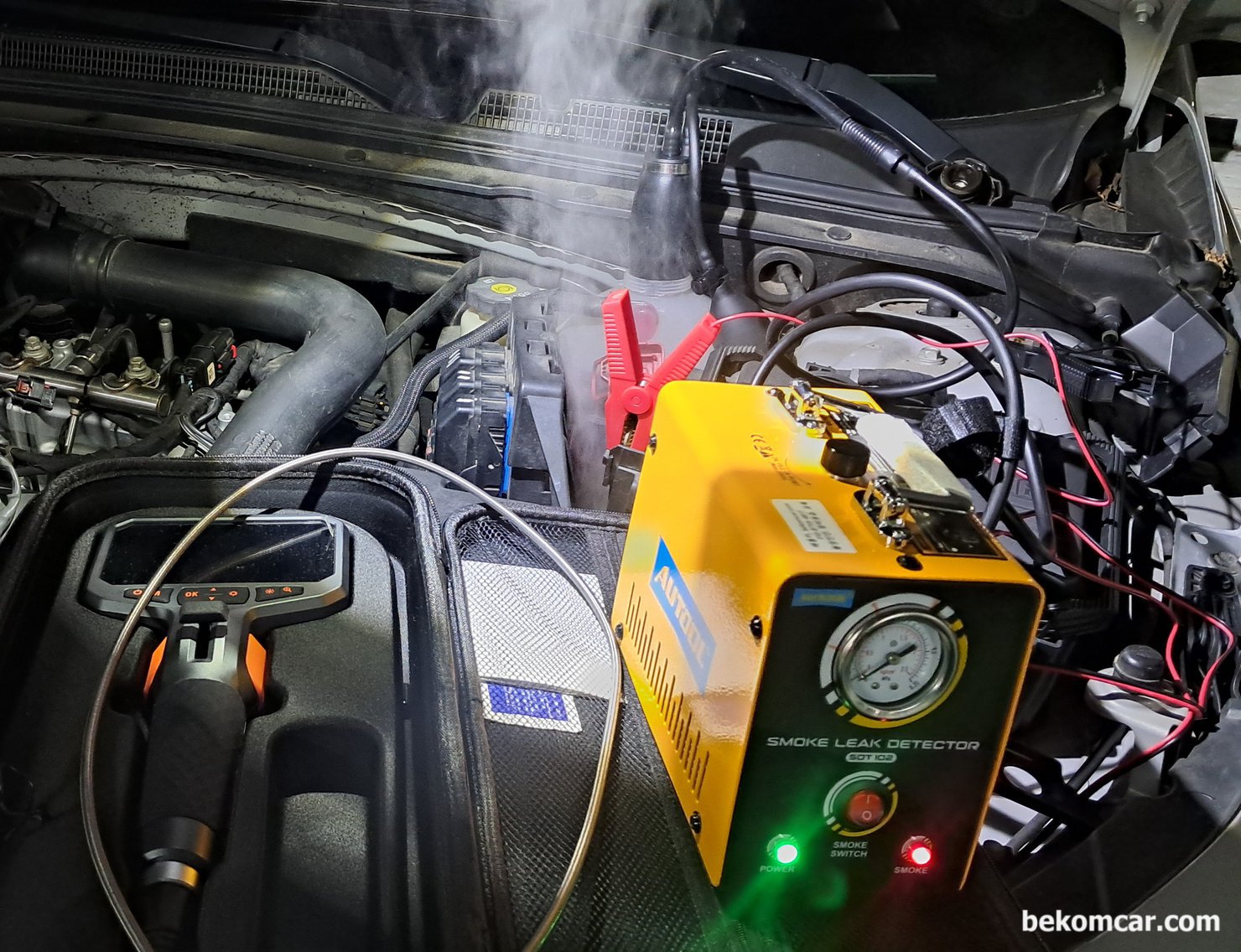 쉐보레 말리부 1.5T 실린더내시경 및 헤드가스켓 냉각수리크 진단과정 기록, 쉐보레 말리부 1.5T 에코텍 엔진 2017년 차량. 냉간시 부조가 있어 헤드가스켓 누수등 점검을 하고 있다. 냉각수 보조통에 압력을 넣어서 헤드와 블록 사이에서 냉각수가 흐르는지 확인하는 과정이다. 하지만 상당한 스모크 가 나오는데 냉각수 보조통 아래에서 스모크머신 스모크가 나오고 있다. 실제 보면 상당한 양의 스모크 이다. 말리부에서 흔하게 발생하는 냉각수 보조통 크랙이 있는것으로 판단된다.|bekomcar.com
